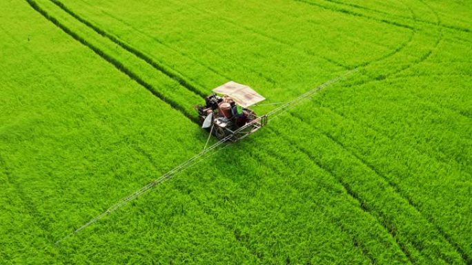稻田上的鸟瞰杀虫剂喷洒机。