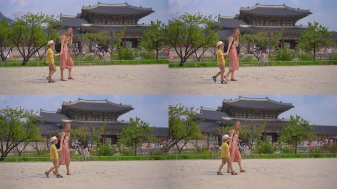 年轻女子和她的小儿子参观了韩国首尔的古代宫殿。去韩国旅游概念。慢动作镜头