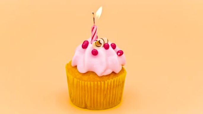 橙色背景上带有红色蜡烛的生日蛋糕。