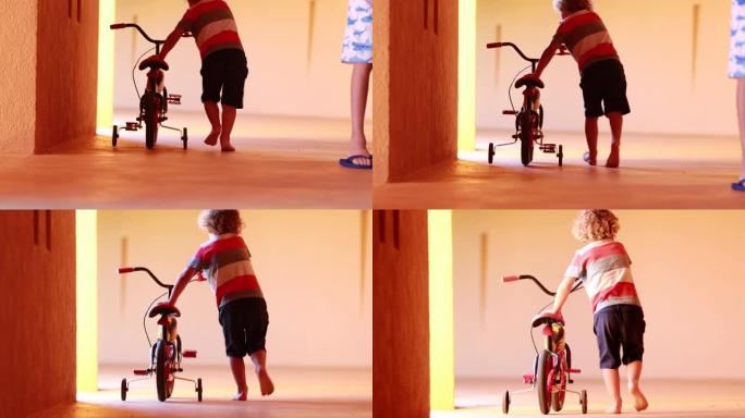 小男孩背着trycicle孩子学习骑trycicle