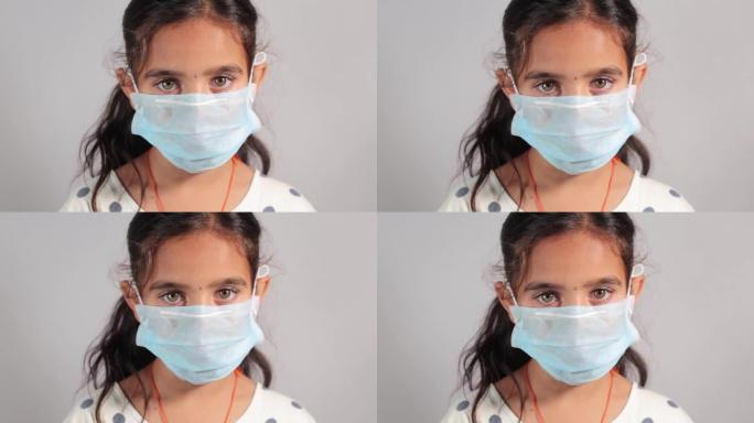 戴着医用口罩的年轻女孩看着相机，显示冠状病毒或covid-19爆发 -- 戴着病毒感染防护口罩的少女