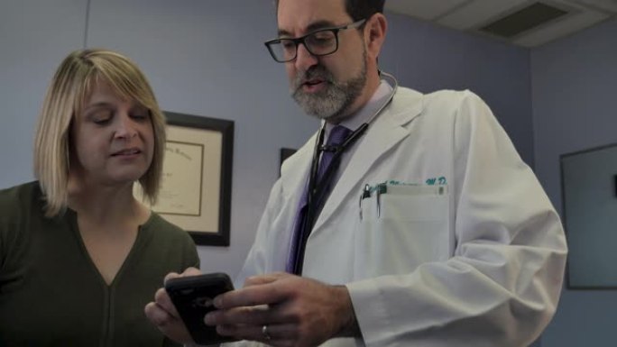 男医生教女患者如何使用智能手机医疗应用程序
