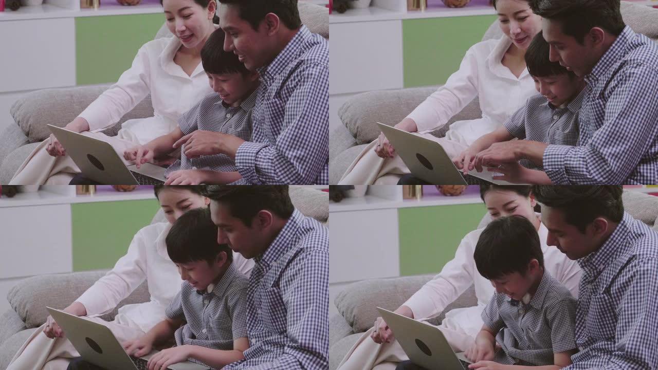 亚洲家庭父母和儿子使用笔记本电脑申请申请观看家庭娱乐。霍利迪家庭度假与家庭技术
