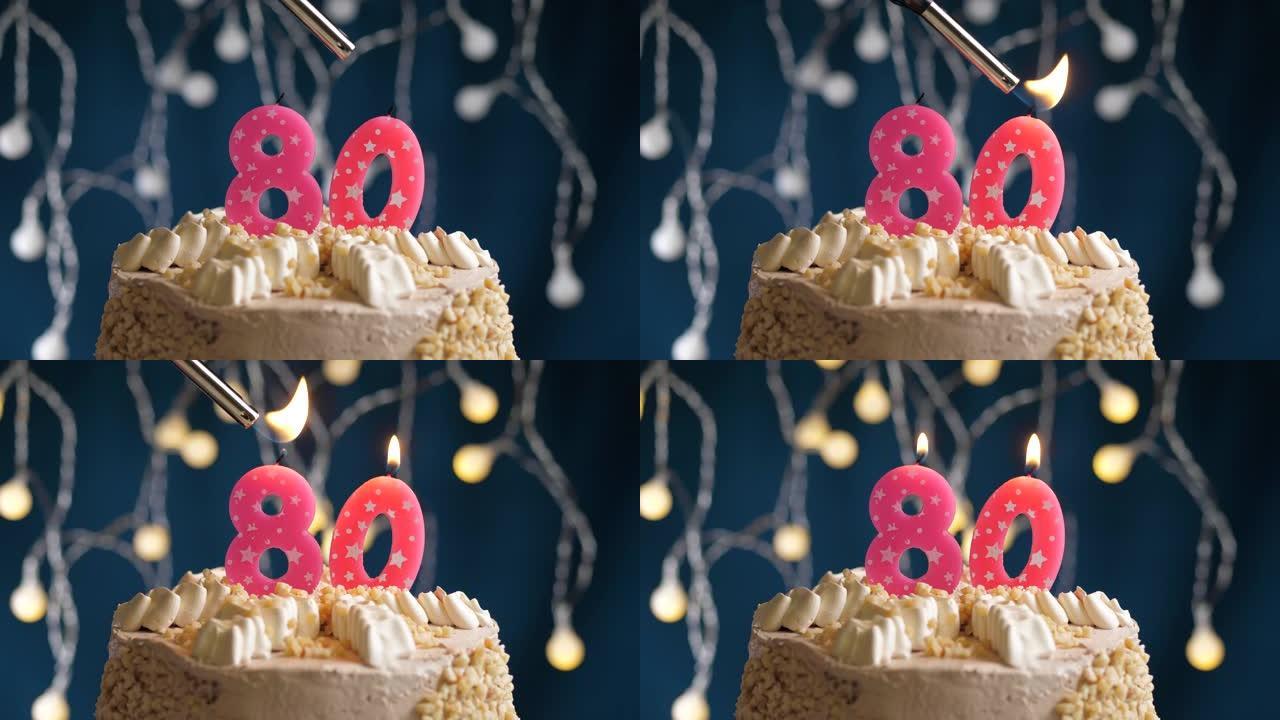 蓝色背景上有80号粉色蜡烛的生日蛋糕。蜡烛着火了。慢动作和特写视图