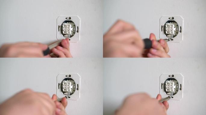 电工用螺丝刀固定电插座。室内开关和插座的杂工