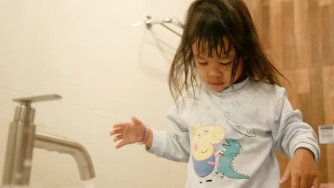 快乐的小女孩在浴室刷牙洗脸。口腔卫生概念。