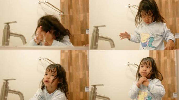 快乐的小女孩在浴室刷牙洗脸。口腔卫生概念。