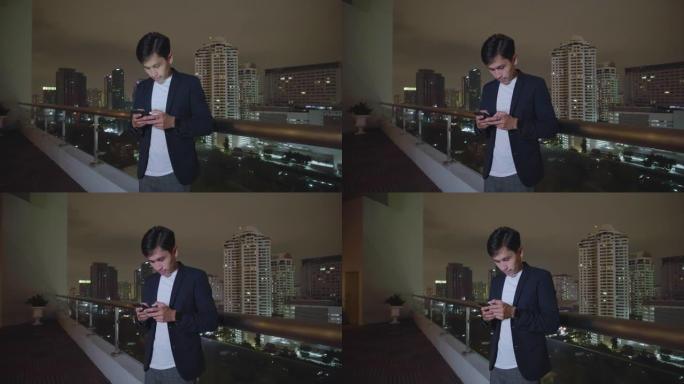 亚洲男子在午夜街头城市使用智能手机，绝望，失望