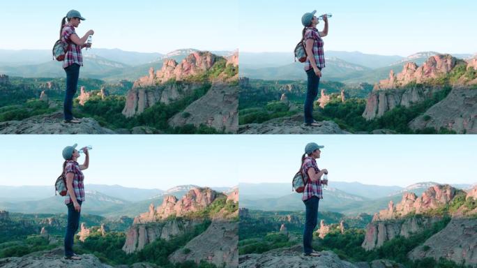 回归自然。单人旅行者在美丽的全景前，从高处俯瞰美丽的红色岩层。一个快乐的年轻女子游客走在大自然中。饮