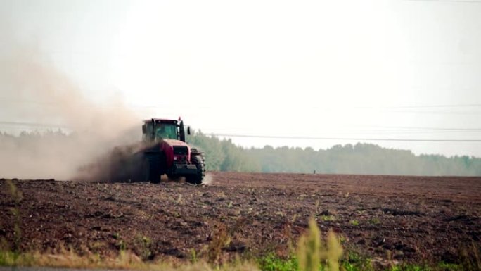 农业综合企业: 能源密集型拖拉机上的农民在炎热干燥的天气中犁出干旱，尘土飞扬的土壤