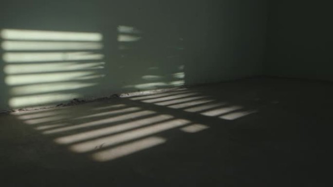 百叶窗阴影在一个废弃的房间滑块平底锅的地板上