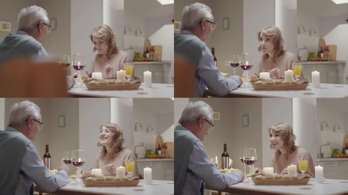 欢乐的老年夫妇在浪漫的晚餐上聊天