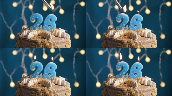 蓝色背景上有26个数字蜡烛的生日蛋糕。蜡烛着火了。慢动作和特写视图