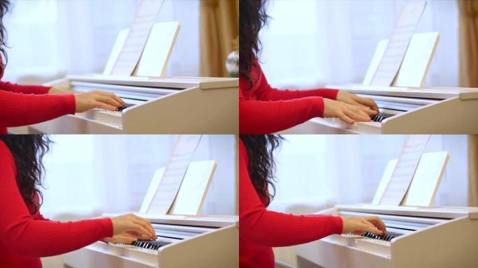 女子或女学生或专业钢琴家在美丽的白色钢琴上演奏古典音乐，圣诞节假期在圣诞树和闪烁的新年灯光的背景下。
