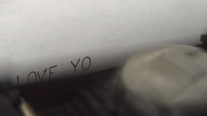 在一台旧的机械打字机上用黑色墨水打字我爱你。