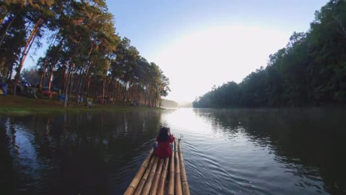 亚洲女子竹筏漂流与森林自然景观在早晨。旅游概念