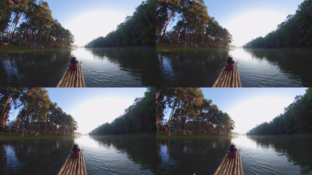 亚洲女子竹筏漂流与森林自然景观在早晨。旅游概念