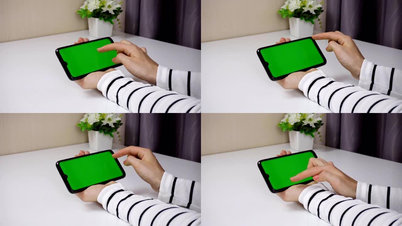 年轻女子使用带有垂直绿色屏幕的智能手机。