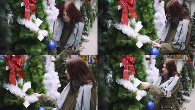 一个年轻漂亮的女人在商店里走来走去，挑选圣诞装饰品和装饰品庆祝新年。新年购物