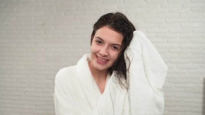 女孩用毛巾擦干湿头发。