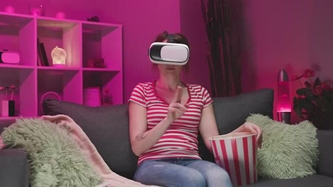 年轻女子晚上戴VR耳机和触摸虚拟屏幕