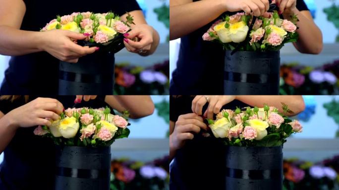 花店妇女在商店的黑匣子包装中制作玫瑰花束，特写镜头。
