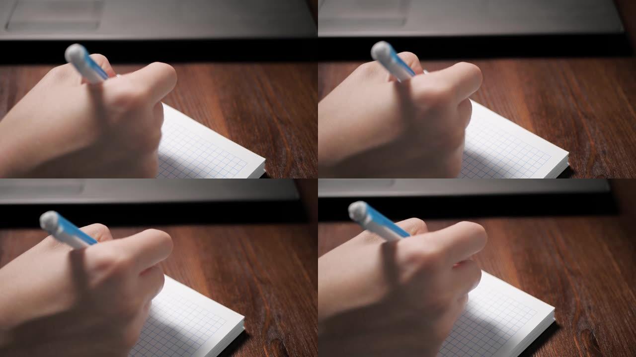 女手用笔在笔记本上写东西，旁边是笔记本电脑。特写慢动作