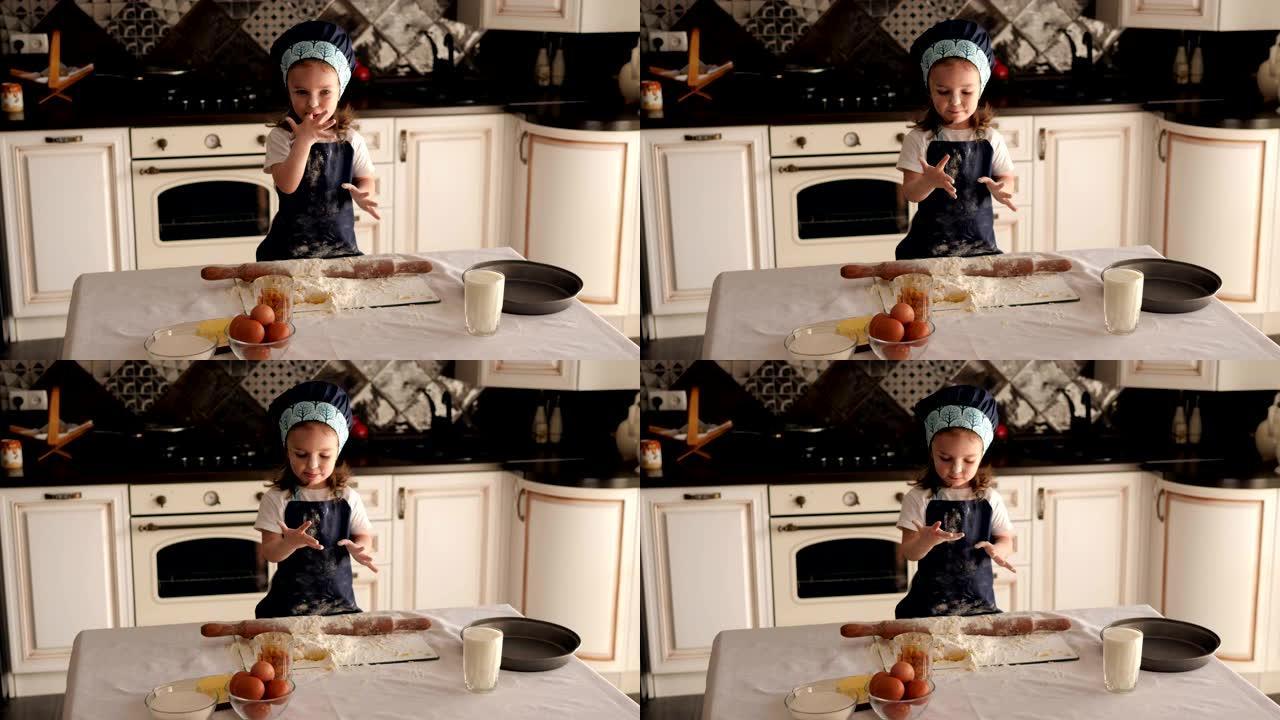 可爱的小女孩在厨房里用面团舔她的手指。