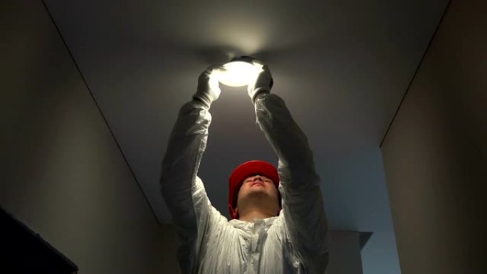 专业电工安装圆形发光二极管灯进入天花板孔