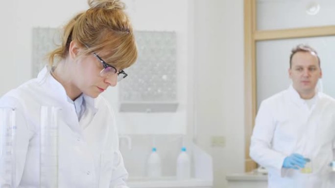 两名科学家正在实验室中研究萜烯晶体和药片