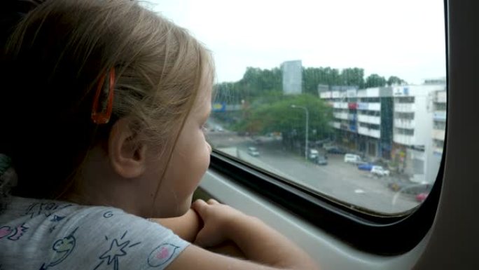 小女孩在旅途中向火车窗外望去
