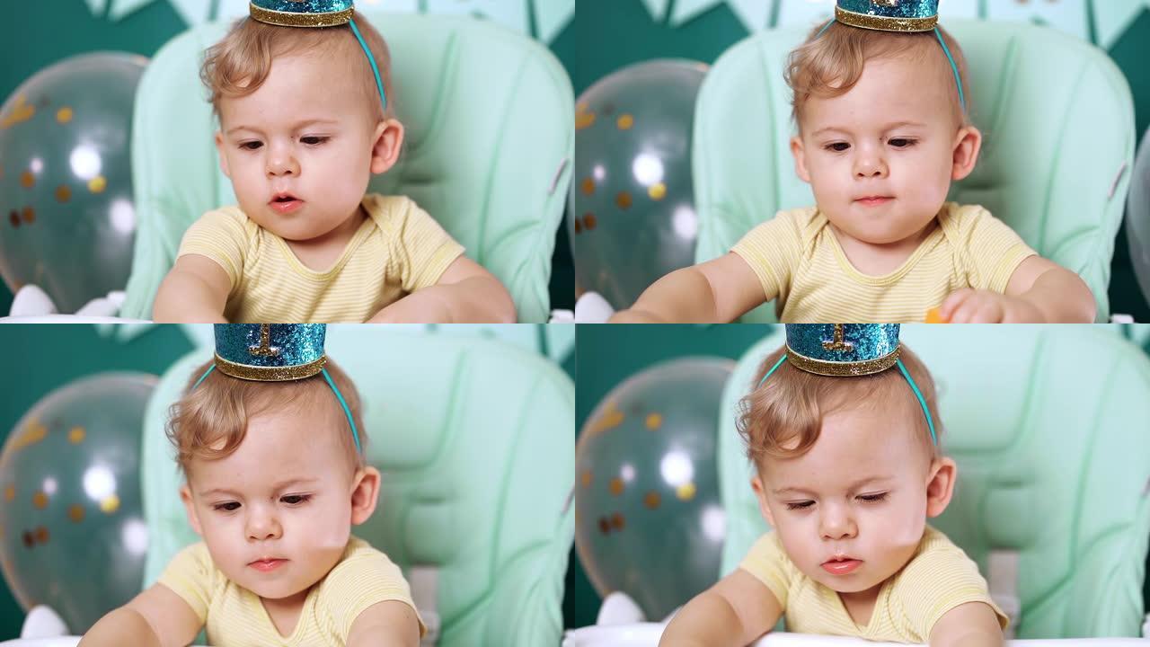可爱的男婴坐在椅子上，玩五颜六色的砖块。生日英俊的蹒跚学步的大眼睛孩子肖像。有趣的孩子。