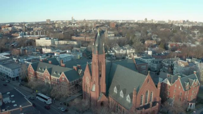 空中无人机穿过街道朝波士顿郊区的一座砖砌教堂射击