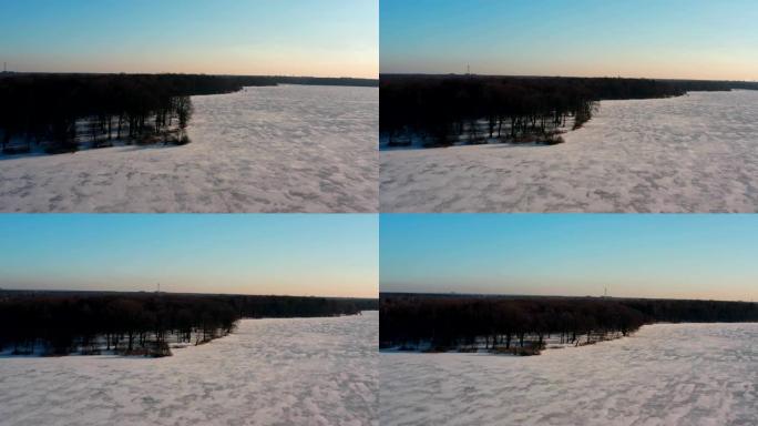 无人机在冬季景观，冰冻的湖泊和周围的森林中的景色