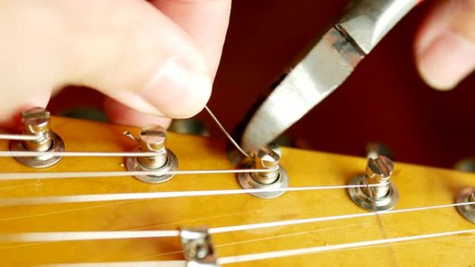 切断多余的吉他弦。改变电吉他弦的过程。