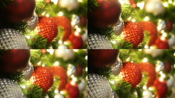 节日装饰的户外圣诞树的特写镜头，模糊的闪闪发光的童话背景上有鲜红色的球。散焦花环灯，波克效应。圣诞快