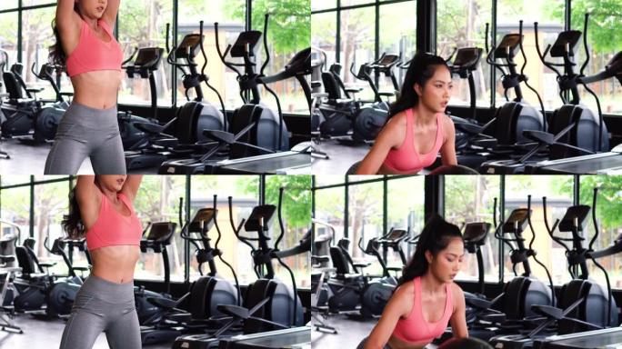 在健身俱乐部锻炼时，坚定而认真的活跃的亚洲女运动员蹲在药球上