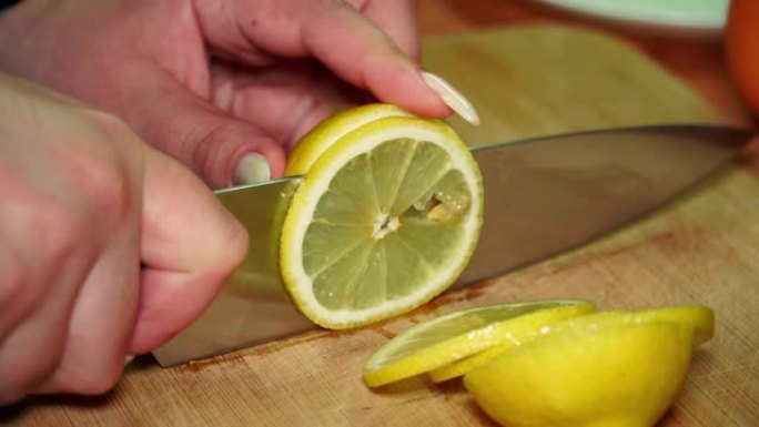 一个女孩用小刀在木板上切多汁的成熟维生素黄色柠檬