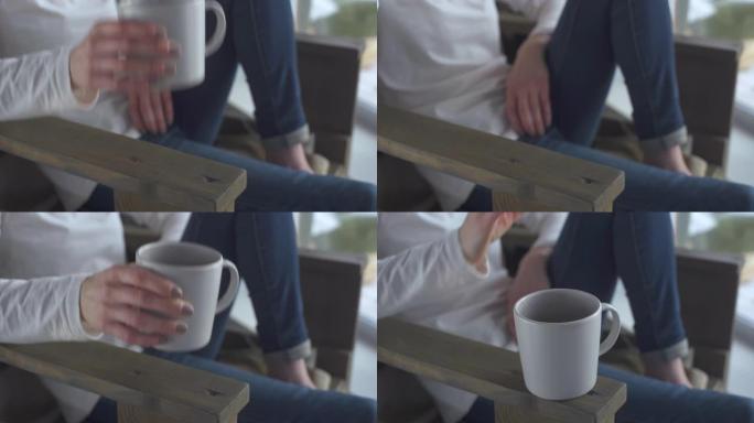 一个冬天的早晨坐在椅子上的快乐美丽的短发女孩早上在她的房子里喝杯咖啡。年轻女子从杯子里喝茶。热饮。单