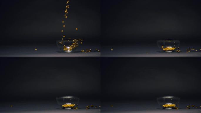 黄色糖果慢动作落在玻璃碗中，黑色黑板纹理背景上有复制空间