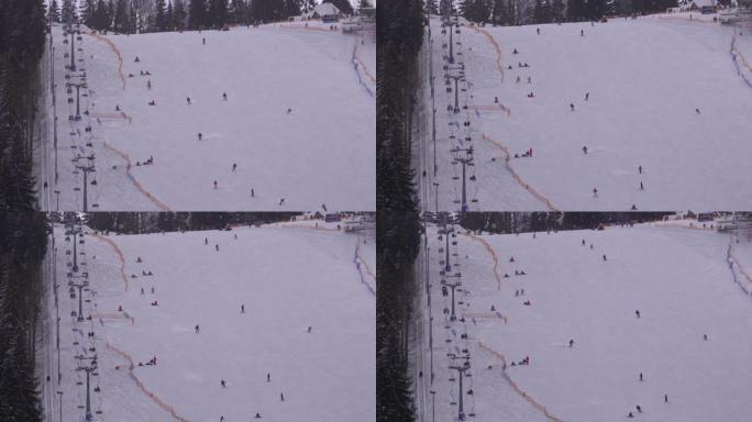 晴天，滑雪者和滑雪者在滑雪胜地的雪坡上骑行