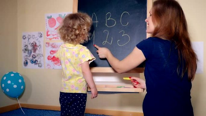 细心的女老师教聪明的女孩字母和数字