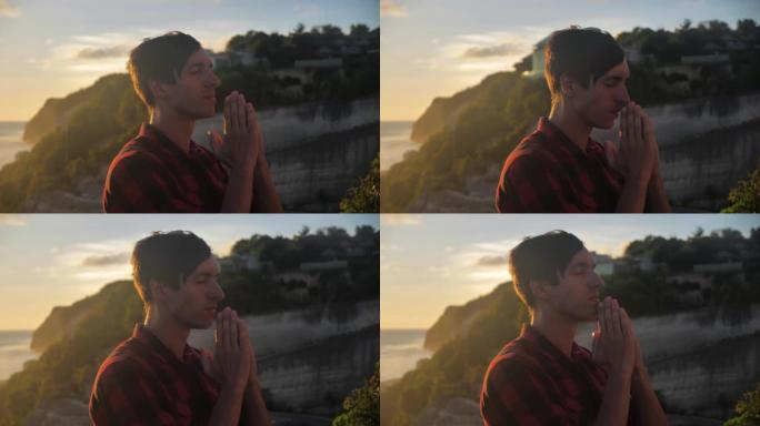 金色日落时，一个人在山顶上向上帝祈祷的肖像。宗教概念