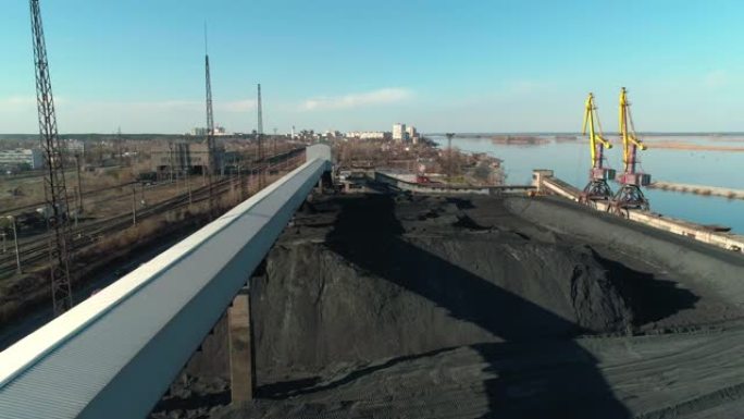 带起重机和输送机的河边露天煤炭仓库的鸟瞰图