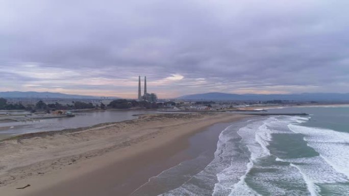 太平洋沙洲上海滩的鸟瞰图，背景是炼油厂。美国西海岸，加利福尼亚州