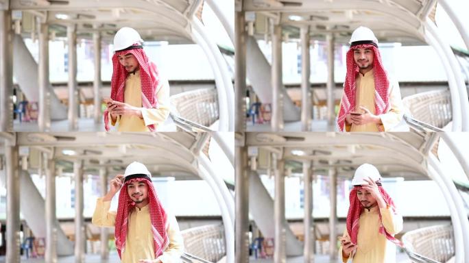 伊斯兰男子使用智能手机应用程序组织日程议程专注于手持智能手机穆斯林现代阿联酋城市。阿拉伯男子穿头巾和