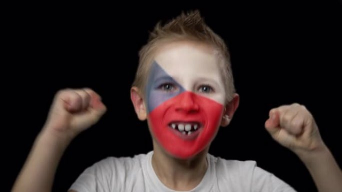快乐的男孩为他最喜欢的捷克队的胜利而欢呼。脸上涂着民族色彩的孩子。