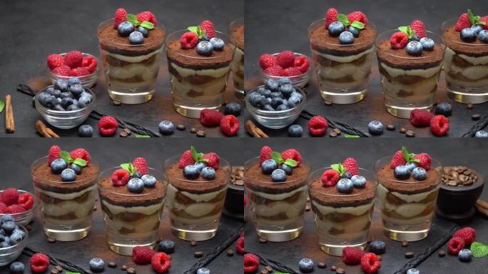 经典提拉米苏甜点，蓝莓和覆盆子放在石头上菜板上的玻璃杯中
