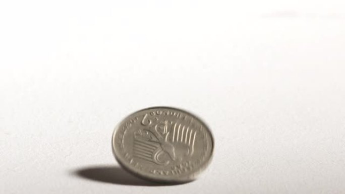 2德国马克硬币旋转并落在桌子上。