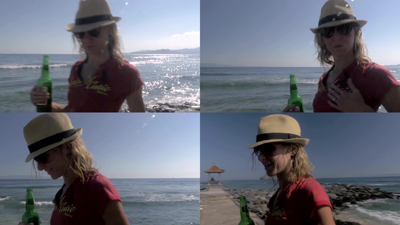 一个漂亮的年轻女子带着啤酒在沙滩上散步